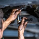 🎯 Homem garante aposentadoria após reconhecimento de exposição a hidrocarbonetos! 3 car mechanic doing repair maintenance oil change to the car on the hydraulic car lift car vehicle service 700x468 1